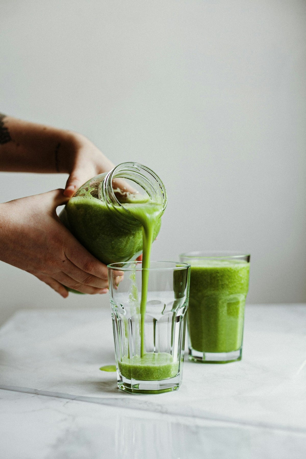 Pouring a green drink into a glass