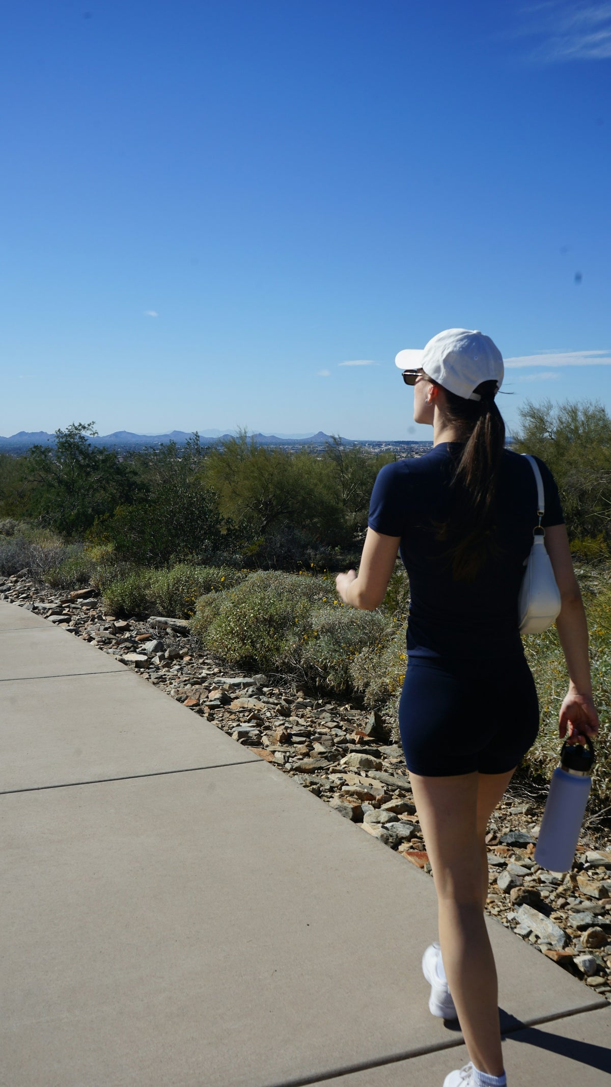 Woman walking a desert trail in the morning
